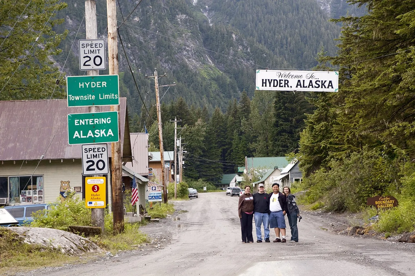 Road trippers in front of the Welcome to Hyder, Alaska sign.