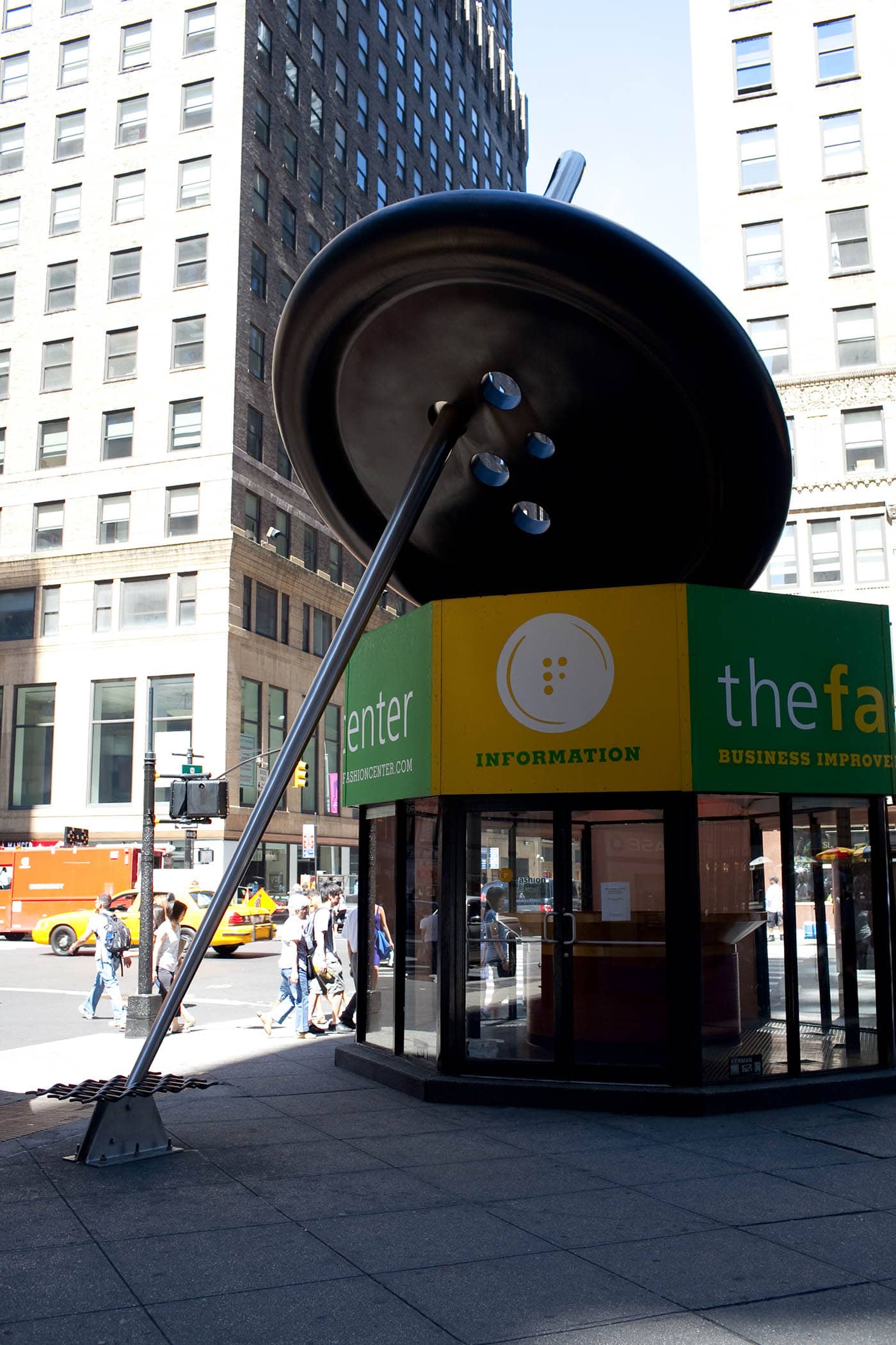 Giant sewing needle threading a button in New York City's Fashion District.