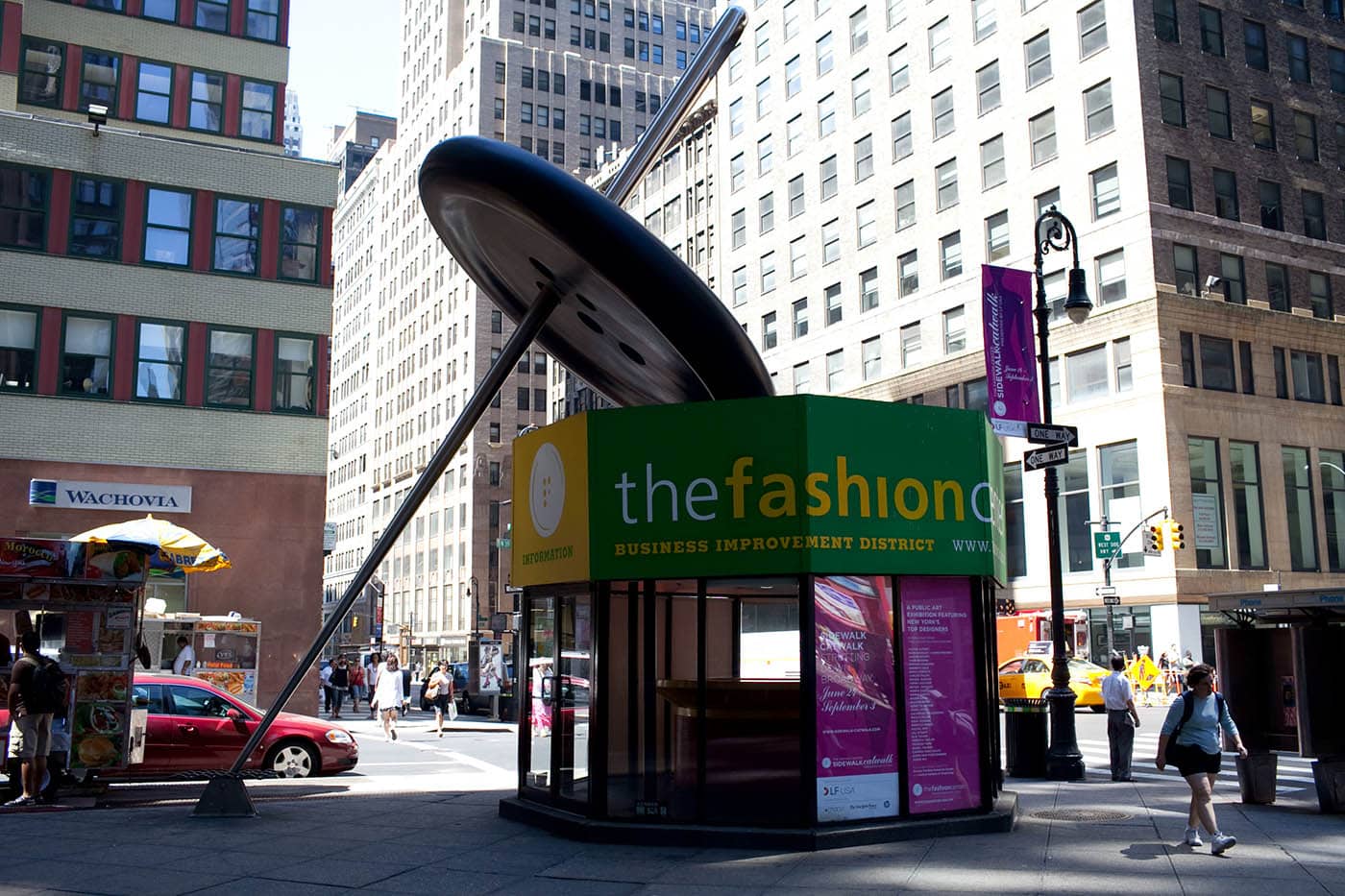 Giant sewing needle threading a button in New York City's Fashion District.