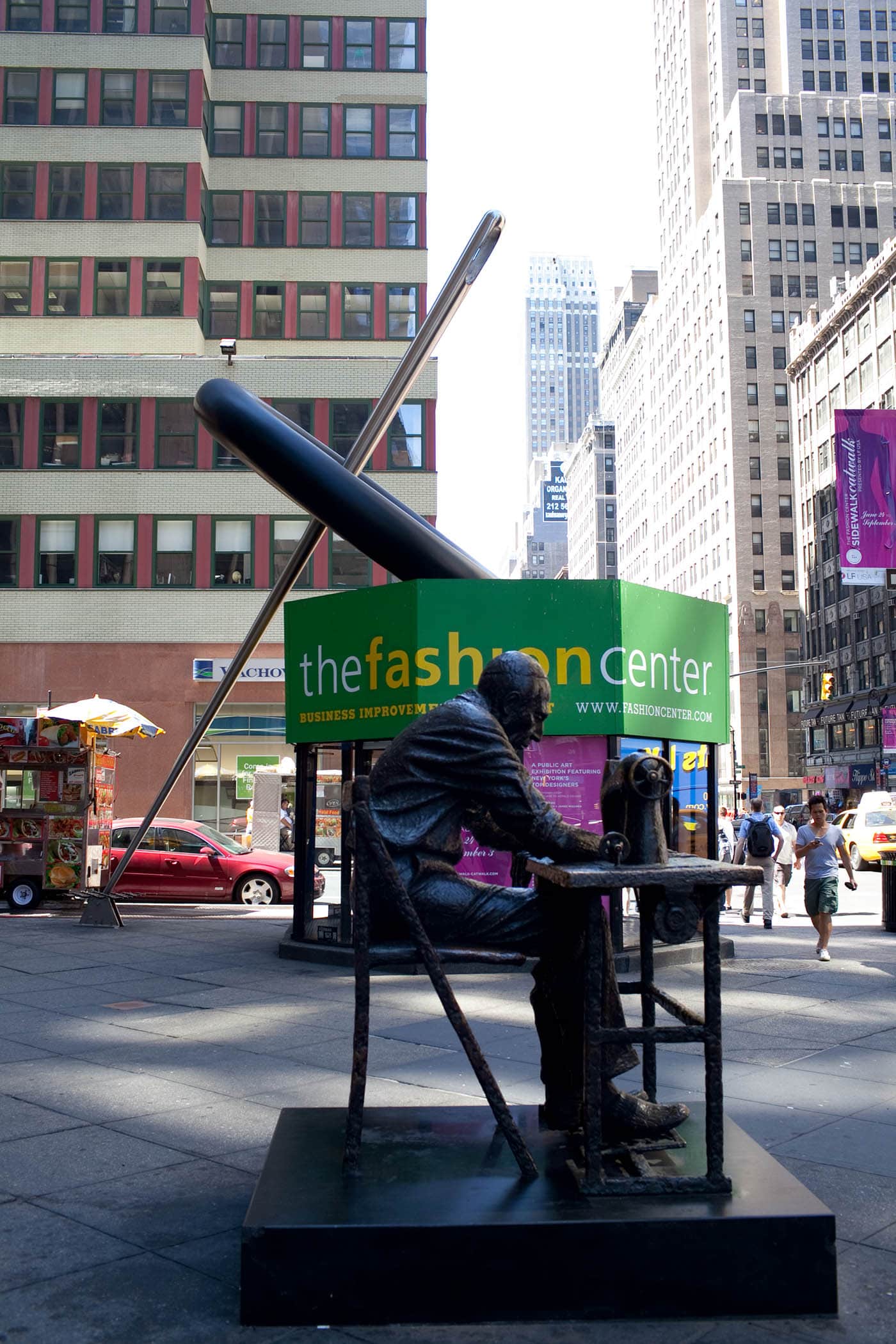 Giant sewing needle threading a button in New York City's Fashion District.