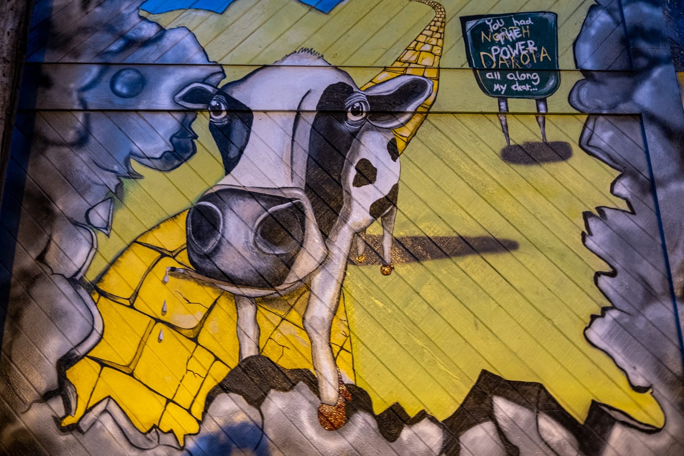 Mahalia Mees cow meets Wizard of Oz "Going Home" mural declares, "You had the power all along my dear..." Alley 5.5: Bismarck Art Alley in North Dakota - Street art and Murals in Bismarck, North Dakota
