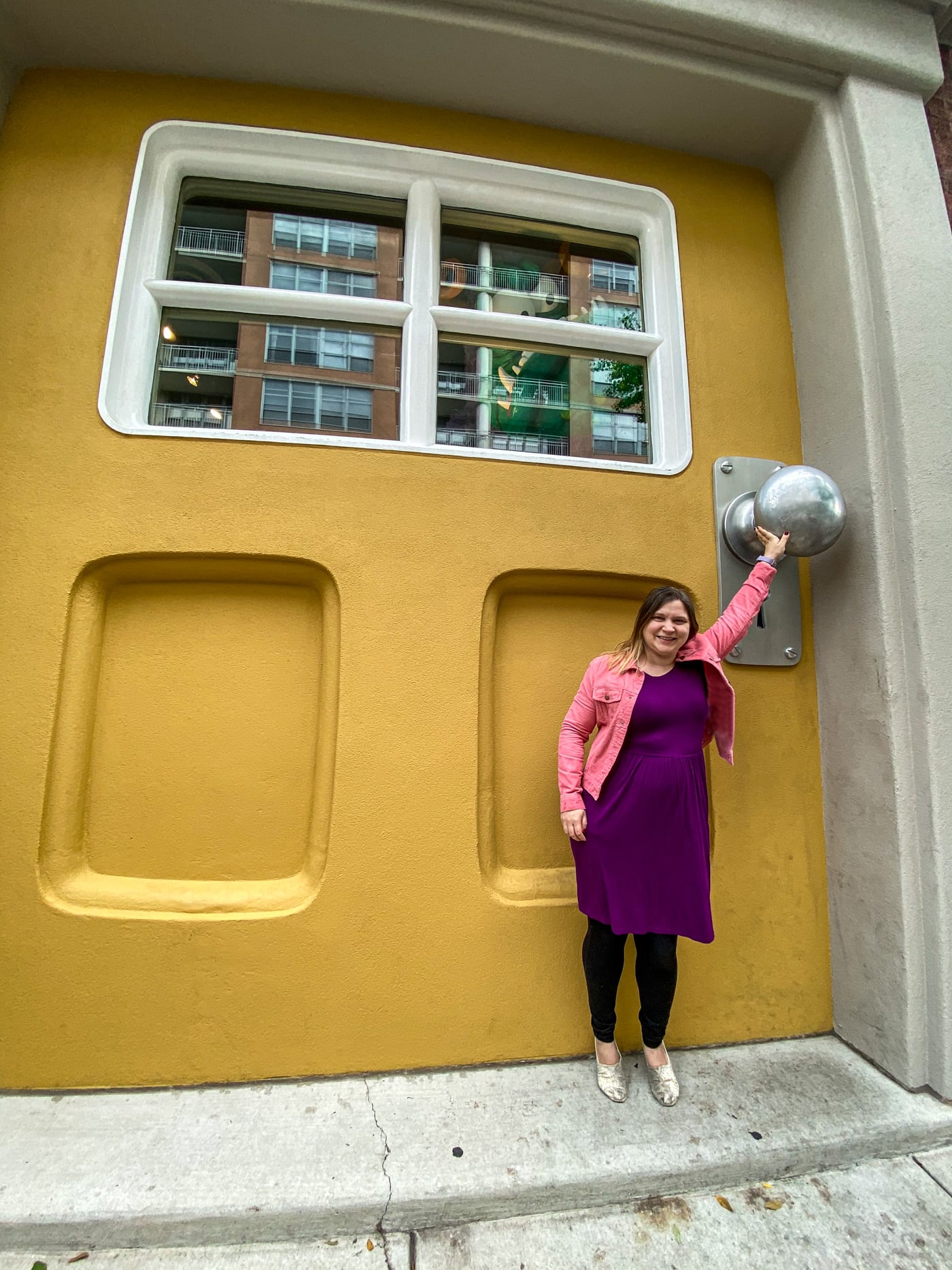 Big Monster Door at Big Monster Toys in Chicago, Illinois | A giant yellow door with a monster peeking out the window in the West Loop