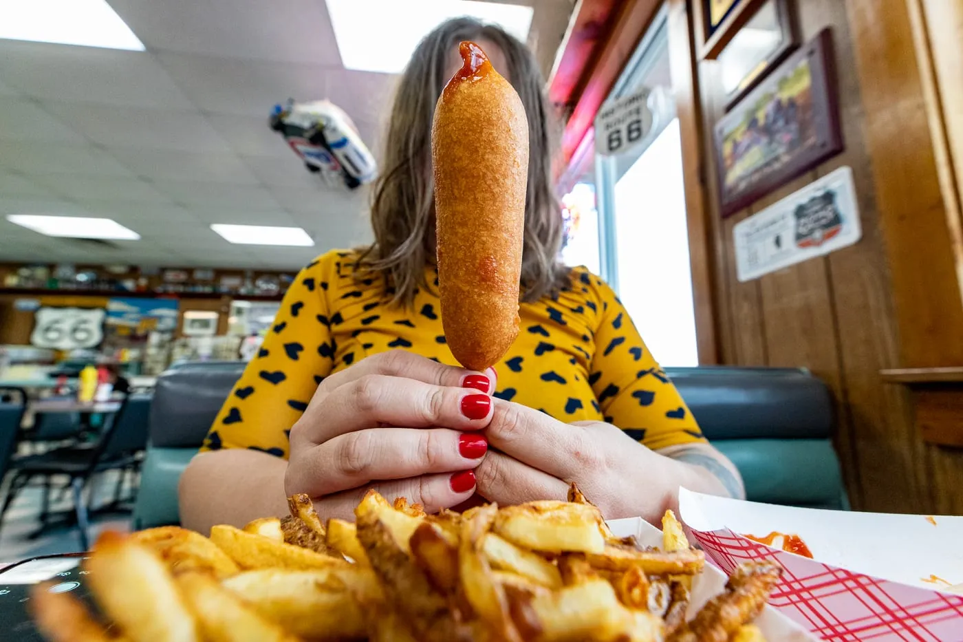 Eating a cozy dog corn dog at Cozy Dog Drive In in Springfield, Illinois on Route 66
