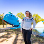 Valerie Bromann - writer author and road tripper - standing in front of the Blue Whale of Catoosa