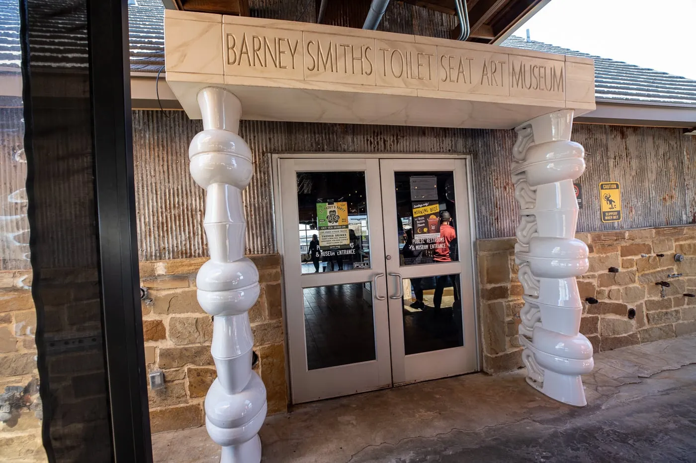 Stacked porcelain toilets at the Entrance to Barney Smith's Toilet Seat Art Museum in The Colony, Texas at The Truck Yard Bar