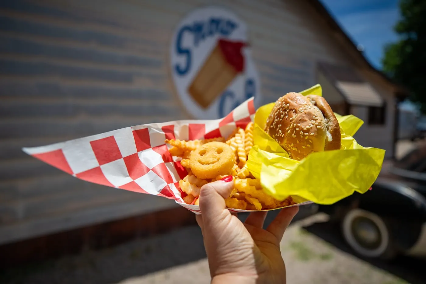 Cheeseburger with cheese, fries, a Smiles face fry, and a chocolate milkshake at Delgadillo’s Snow Cap in Seligman, Arizona - Route 66 restaurant and Drive-In Diner